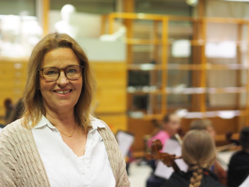 Susanne Norrbäck-Råman står framför en orkester av barn.